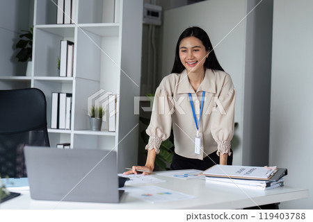Businesswoman Working on Laptop in Modern Office, Smiling and Engaged in Professional Work Environment Businesswoman Working on Laptop in Modern Office, Smiling and Engaged in Professional Work Environment 119403788