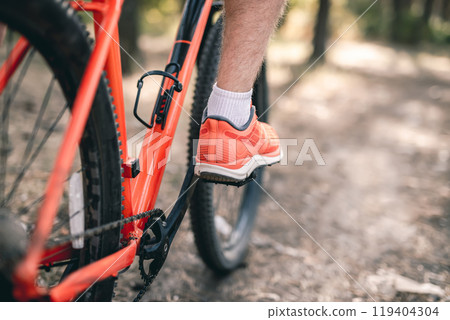 Leg in sneaker on bicycle pedal Leg in sneaker on bicycle pedal 119404304