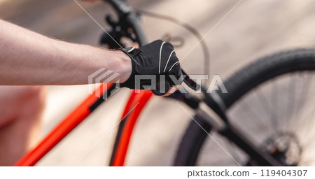 Hand in sport glove on handlebar 119404307