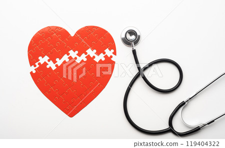 Stethoscope next to heart shaped puzzle 119404322