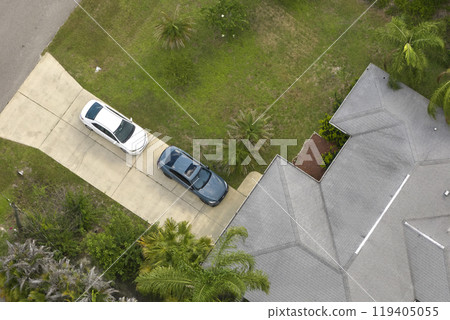 Aerial view of typical contemporary american private house with roof top covered with asphalt shingles and green lawn on yard Aerial view of typical contemporary american private house with roof top covered with asphalt shingles and green lawn on yard 119405055