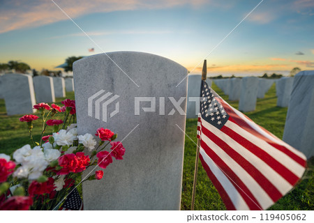 American army national cemetery with rows of white headstones decorated with flowers and USA flags on green grass lawn. Memorial Day concept 119405062