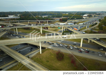 American freeway intersection with fast driving cars and trucks. View from above of USA transportation infrastructure American freeway intersection with fast driving cars and trucks. View from above of USA transportation infrastructure 119405064
