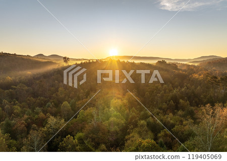 Appalachian mountain hills on autumn evening with brightly illuminated lush and pine woods at fall season. Autumnal landscape of beautiful nature Appalachian mountain hills on autumn evening with brightly illuminated lush and pine woods at fall season. Autumnal landscape of beautiful nature 119405069