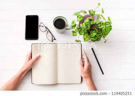 Top view of girl holding notebook on white table 119405251