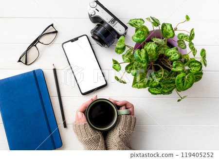 Top view of girl holding coffee mug at working place 119405252
