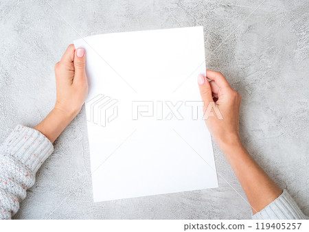 Girl's hands holding sheet of paper 119405257