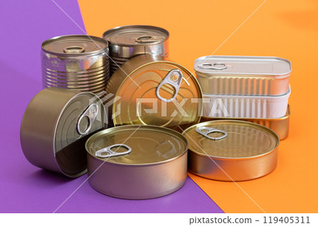 A Group of Stacked Tin Cans with Blank Edges on Split Orange and Violet Background A Group of Stacked Tin Cans with Blank Edges on Split Orange and Violet Background 119405311
