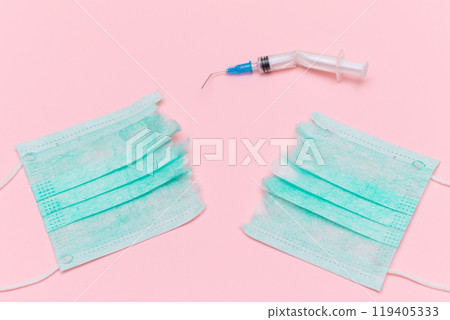 Broken Medical Syringe and Torn Medical Face Mask on the Pink Background 119405333
