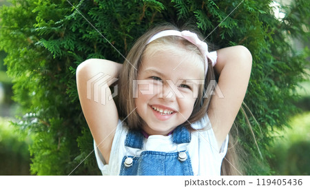 Portrait of pretty child girl standing outdoors in summer park smiling happily. Portrait of pretty child girl standing outdoors in summer park smiling happily. 119405436