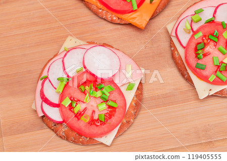 Crispy Cracker Sandwiches with Tomato, Sausage, Cheese, Green Onions and Radish 119405555