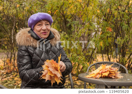 Senior woman in autumn park outdoors Senior woman in autumn park outdoors 119405620