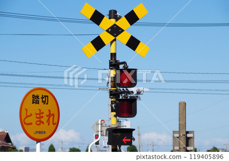 A railroad crossing alarm with a left-pointing arrow on it 119405896