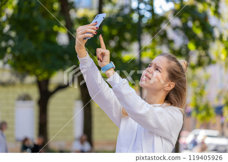 Young female tourist trying to catch a communication signal and Internet on cellphone in city street Young female tourist trying to catch a communication signal and Internet on cellphone in city street 119405926