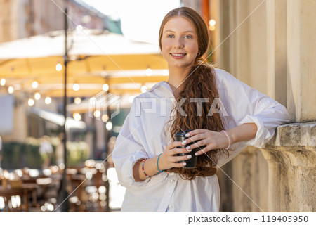 Teen child girl enjoying drinking morning coffee hot drink, relaxing, taking a break in city street Teen child girl enjoying drinking morning coffee hot drink, relaxing, taking a break in city street 119405950