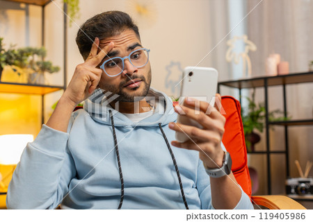 Sad Indian man use smartphone surprised by bad news, fortune loss, fail, lottery results, deadline Sad Indian man use smartphone surprised by bad news, fortune loss, fail, lottery results, deadline 119405986