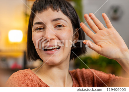 POV of young woman making online video call talking waving hand hello looking at camera blowing kiss POV of young woman making online video call talking waving hand hello looking at camera blowing kiss 119406003