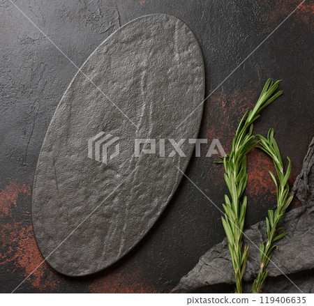 Empty black oval plate and rosemary sprigs on table Empty black oval plate and rosemary sprigs on table 119406635