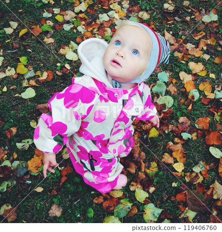 Little girl with blue eyes among colorful fallen leaves Little girl with blue eyes among colorful fallen leaves 119406760