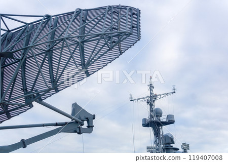 military background, naval radar antenna close up and warship in the background 119407008