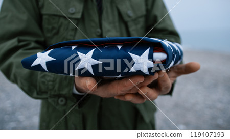 Old Soldier Holding The USA Flag In His Hands Old Soldier Holding The USA Flag In His Hands 119407193