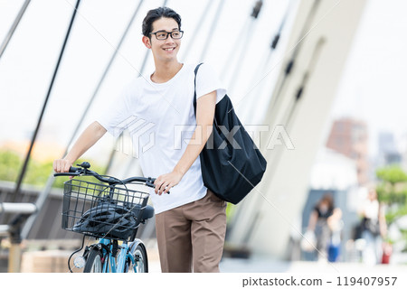 Young man pushing a bicycle 119407957