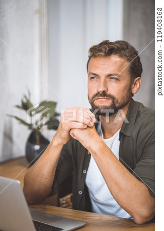 A man sitting in front of a laptop computer. A man sitting in front of a laptop computer. 119408168