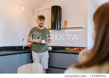 Man enjoying a coffee in a cozy modern kitchen, creating a relaxing morning routine with fruits 119408542