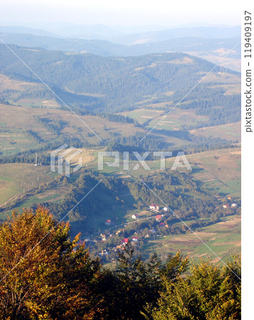 Trees and mountain village in a valley among the highlands 119409197