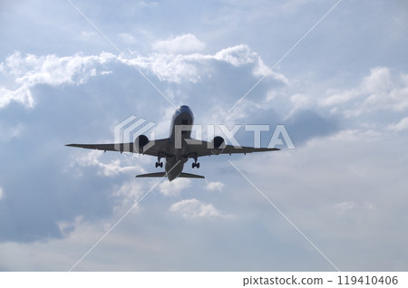 A Boeing 787 jetliner takes off from Yonago Kitaro Airport against the bright afternoon sky. 119410406