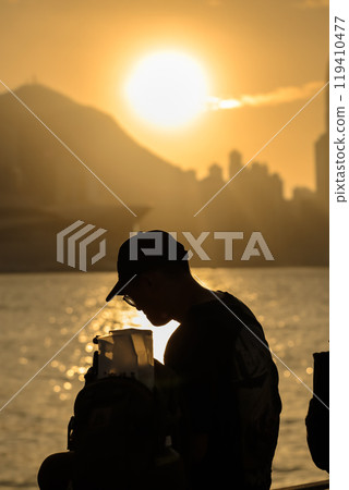 Oct 13 2024 Sunset behind Hong Kong Skyline and Skyscrapers Oct 13 2024 Sunset behind Hong Kong Skyline and Skyscrapers 119410477