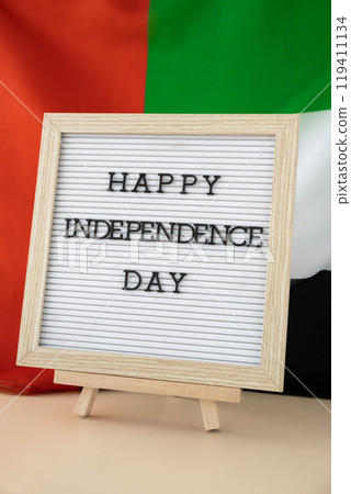 Text HAPPY INDEPENDENCE DAY on background waving flag of UAE. National holiday of United Arab Emirates. Commemoration Day Muslim Arabian holidays. Dubai Text HAPPY INDEPENDENCE DAY on background waving flag of UAE. National holiday of United Arab Emirates. Commemoration Day Muslim Arabian holidays. Dubai 119411134