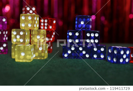 Stacks of Colorful Dice on Green Felt With Bokeh Background Stacks of Colorful Dice on Green Felt With Bokeh Background 119411729