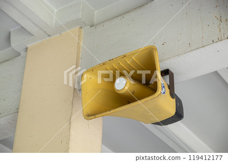 An old-fashioned loudspeaker installed in an old building for public announcements 119412177