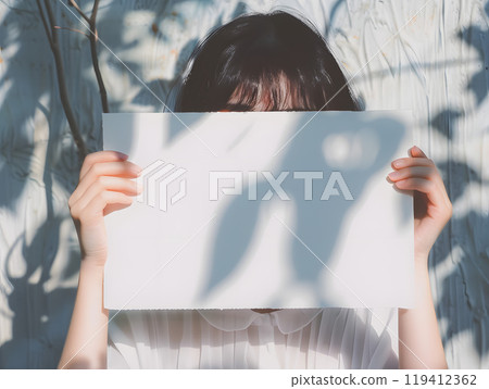 Asian woman holding a whiteboard under the summer sun Asian woman holding a whiteboard under the summer sun 119412362