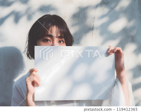 Asian woman holding a whiteboard under the summer sun Asian woman holding a whiteboard under the summer sun 119412365