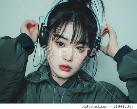 Fashion photo of an Asian woman listening to music through headphones 119412385