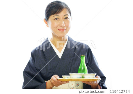A middle-aged woman in a kimono carrying a meal, looking at the camera 119412754