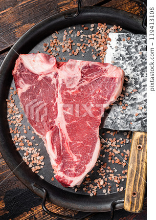 Raw Florentine steak or T bone steak, marbled beef meat in a steel kitchen tray. Wooden background. Top view Raw Florentine steak or T bone steak, marbled beef meat in a steel kitchen tray. Wooden background. Top view 119413108