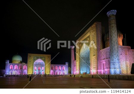 Night view of 15 century madrasahs decorated with mosaics on Registan Square, in colorful lighting Night view of 15 century madrasahs decorated with mosaics on Registan Square, in colorful lighting 119414124