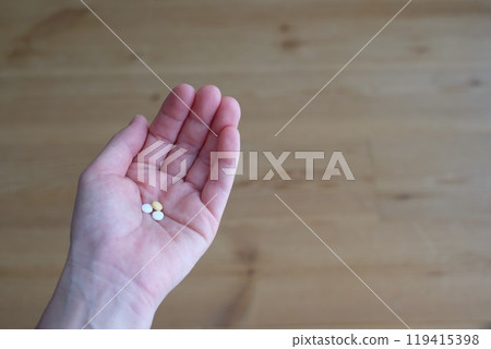 Pill on palm 119415398