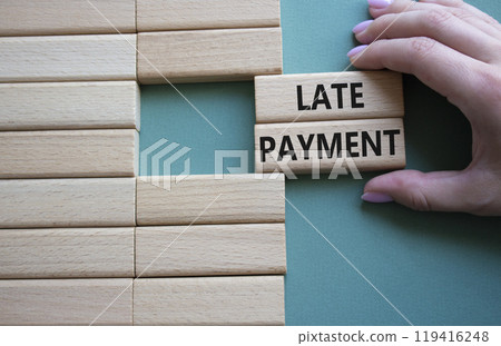Late payment symbol. Concept word Late payment on wooden blocks. Beautiful grey green background. Businessman hand. Business and Late payment concept. Copy space 119416248