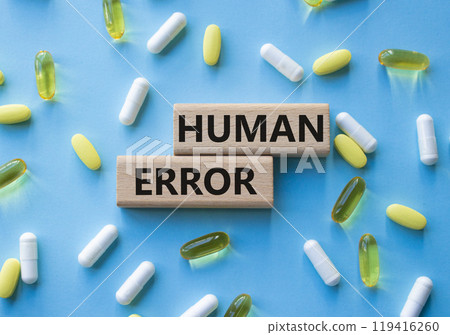 Human Error symbol. Concept word Human Error on wooden blocks. Beautiful blue background with pills. Medicine and Human Error concept. Copy space 119416260
