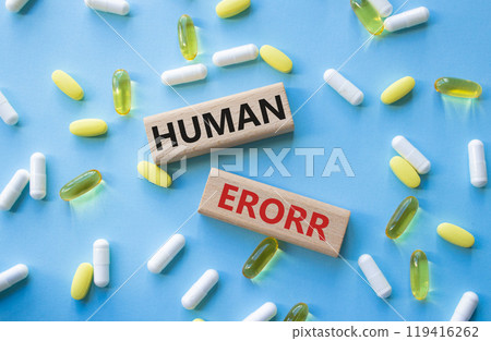 Human Error symbol. Concept word Human Error on wooden blocks. Beautiful blue background with pills. Medicine and Human Error concept. Copy space Human Error symbol. Concept word Human Error on wooden blocks. Beautiful blue background with pills. Medicine and Human Error concept. Copy space 119416262
