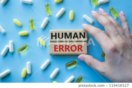 Human Error symbol. Concept word Human Error on wooden blocks. Beautiful blue background with pills. Doctor Hand. Medicine and Human Error concept. Copy space Human Error symbol. Concept word Human Error on wooden blocks. Beautiful blue background with pills. Doctor Hand. Medicine and Human Error concept. Copy space 119416527