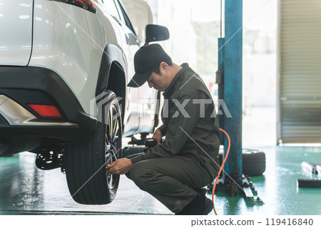 Auto mechanic measuring tire pressure and inflating tires Auto mechanic measuring tire pressure and inflating tires 119416840
