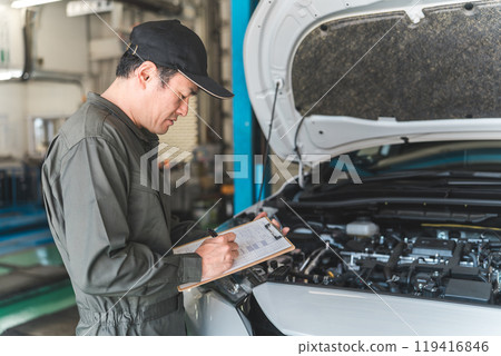 Automobile mechanic checking the engine compartment of a car - Acceptance inspection (vehicle inspection and regular inspection) 119416846