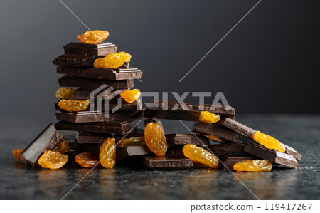 Broken dark chocolate bar with raisins. Broken dark chocolate bar with raisins. 119417267