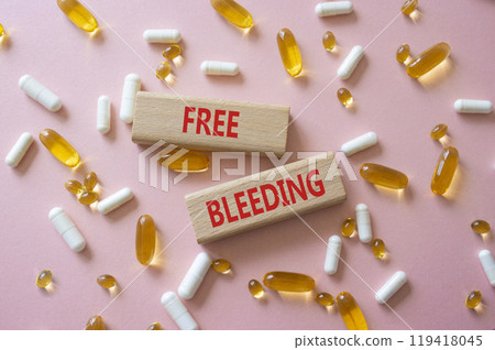 Free bleeding symbol. Concept words Free bleeding on wooden blocks. Beautiful pink background with pills. Motivational and Free bleeding concept. Copy space. 119418045