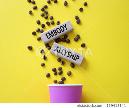 Embody Allyship symbol. Concept word Embody Allyship on wooden blocks. Beautiful yellow background with coffee cup. Business and Embody Allyship concept. Copy space 119418141
